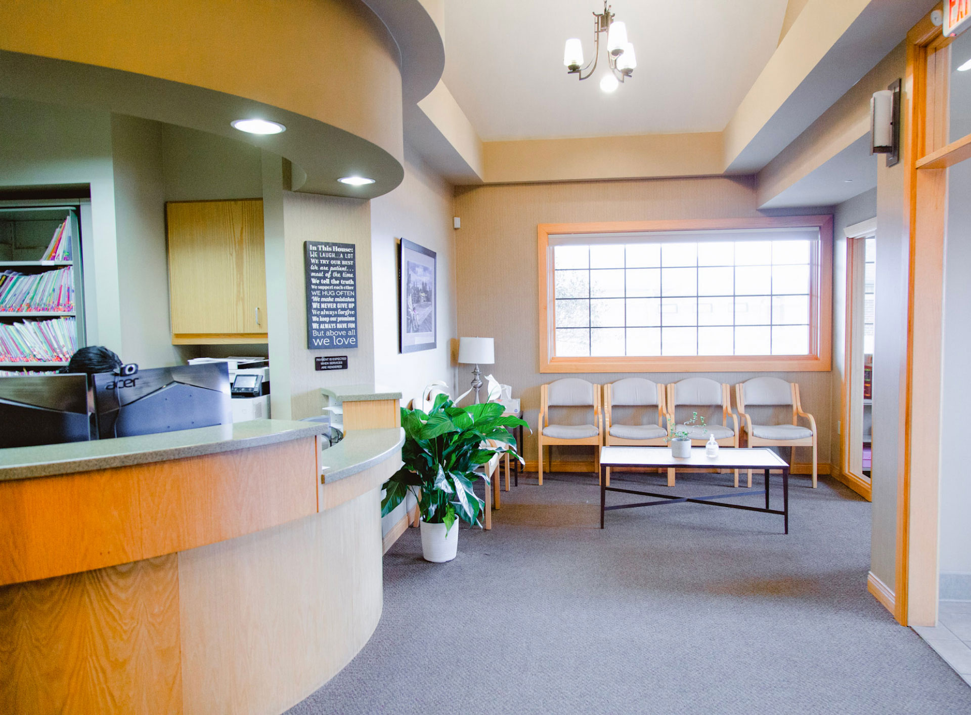 front desk area with beige walls and beige chairs along the back wall